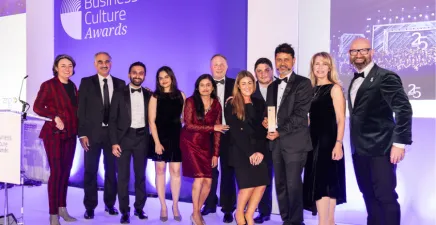 The Overall Winner 2025 is UST, with compere Zoe Lyons, Awards Lead Sponsor Amanda Fajak, Global Culture Practice Leader at ZRG Consulting Solutions and Chair of Judges Tim Pointer